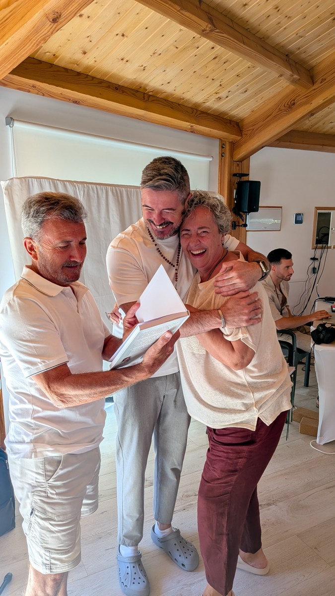 Sergio abraza sonriente a una participante durante un encuentro de la comunidad